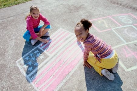 Children drawing with chalk on sidewalk